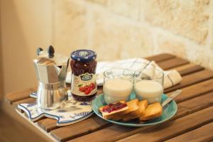 a table with a plate of bread and two glasses of milk at HolidayMonopoli in Monopoli