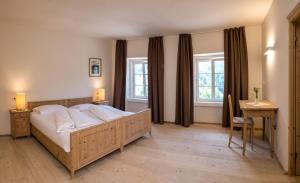 a bedroom with a bed and a desk and two windows at Hotel Kabis in Funes +70 photos