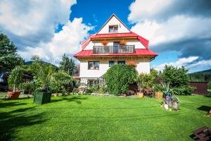 a house with a red roof and a green yard at Apartament Klara in Zakopane