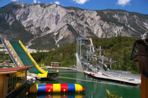a boat in the water next to a mountain at Thalerhof in Roppen