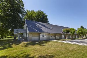 a house with a garage and a grass yard at Campanile Hotel Compiegne in Compiègne