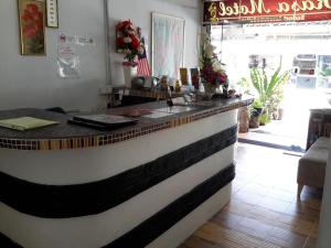 a kitchen with a white counter top and a black counter top at Rasa Motel in Batu Ferringhi