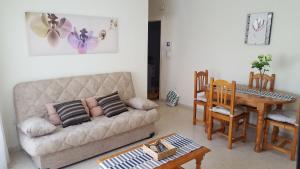 ein Wohnzimmer mit einem Sofa und einem Tisch in der Unterkunft Benaltrigo in Benalmádena
