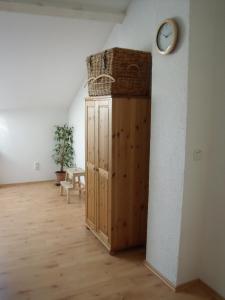 une chambre avec une horloge sur un mur et une armoire en bois dans l'établissement Wasserwerk Trachau, à Dresde