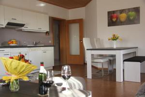 a kitchen and dining room with a table with wine glasses at Auszeit-Wohnungen in Aidenbach