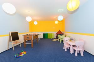 a room with a classroom with tables and chairs at Apartamenty Solaris Premium in Darlowko