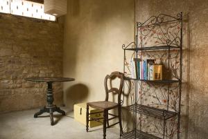 a chair sitting next to a table with a book shelf at Maison de Dame Tartine in Issirac