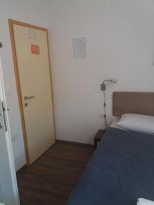 Habitación pequeña con cama, puerta y lámpara en Room Mate Split, en Split