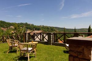 a patio with chairs and tables on the grass at Villa La Verna in Chiusi della Verna