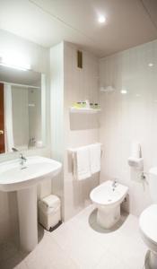 a white bathroom with a sink and a toilet at Insitu Eurotel Andorra in Andorra la Vella
