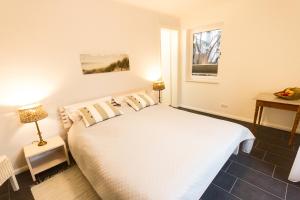 a bedroom with a white bed and a window at Refugium auf Usedom in Ostseebad Karlshagen