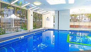 une piscine dans un immeuble avec une grande fenêtre dans l'établissement Seacrest Beachfront Apartments Gold Coast, à Gold Coast