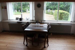 mesa y sillas en una habitación con ventana en Sir Gamle Skole Holstebro en Holstebro
