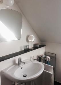 een badkamer met een witte wastafel en een spiegel bij Stadtvilla Hameln in Hameln