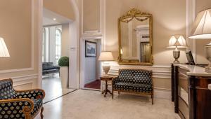 sala de estar con 2 sillas y espejo en Hotel La Fortezza en Florencia