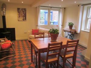 a living room with a wooden table and chairs at Carpenter's Cottage in Pocklington