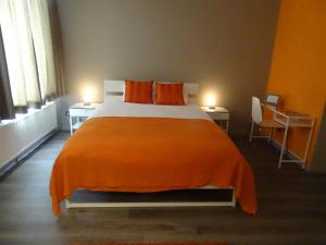 a bedroom with a large bed with an orange blanket at Suite 11 in Antwerp