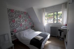 a small bedroom with a bed with a floral headboard at Au Jardin Saint Laurent in Eu