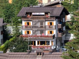un edificio con un balcón con flores. en Hotel Italo, en Madonna di Campiglio