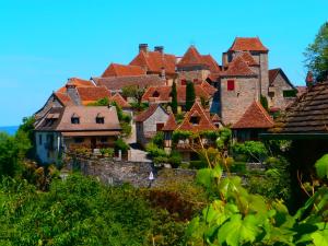 Une rangée de maisons avec des toits rouges sur une colline dans l'établissement la chomiarde, à Saint-Médard-de-Presque