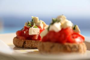 two pieces of bread with tomatoes and cheese on it at Asteria Studios in Potos