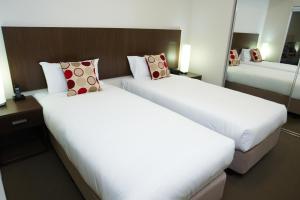 a hotel room with two beds and two lamps at Quest Shepparton in Shepparton