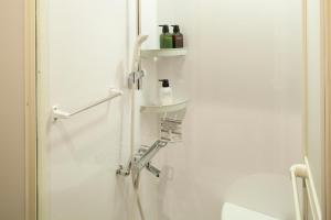a white bathroom with a sink and a shower at Kanazawa Capsule Hotel Musashimachi in Kanazawa