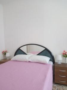 a pink bed with a black frame and white pillows at Sweet Stay Home in Rome