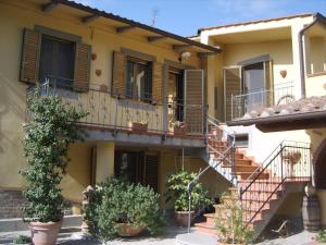 un edificio de apartamentos con escaleras y macetas en Casa Vacanze "La Farfalla" en San Miniato