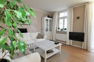 - un salon avec un canapé blanc et une télévision dans l'établissement FeWo Schweriner Altstadt, à Schwerin