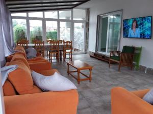 a living room with orange couches and a table and chairs at Apartamentos Barrosa in Portonovo