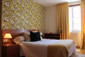 Hotel Montero في موندينيدو: غرفة نوم مع سرير وورق جدران أصفر