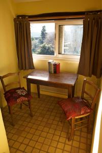 un tavolo e due sedie davanti a una finestra di Maison de Dame Tartine a Issirac