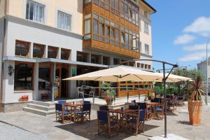 restauracja ze stołami i parasolami przed budynkiem w obiekcie Hotel Montero w mieście Mondoñedo