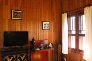 sala de estar con TV de pantalla plana y ventana en Green Plateau Lodge, en Banlung