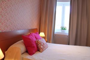 sypialnia z łóżkiem z różowymi poduszkami i oknem w obiekcie Hotel Montero w mieście Mondoñedo
