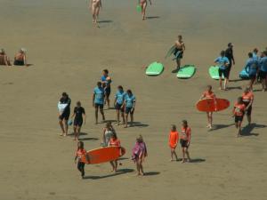 un grupo de personas en la playa con tablas de surf en loft front de mer, garage privé, en Hendaya