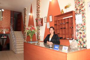a woman sitting at a counter in a store at Hotel Los Gladiolos in Cajamarca