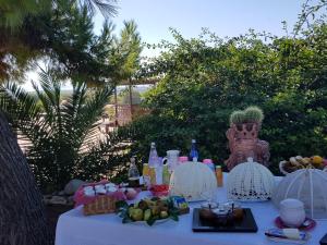 a white table with food and drinks on it at Terre Di Vendicari in Noto
