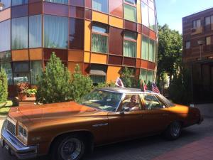 a brown car parked in front of a building at Arunes Apartments in Palanga