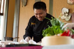 Un homme sourit en se tenant à côté d'une table dans l'établissement Sireeampan Boutique Resort and Spa, à Chiang Mai 55 autres photos