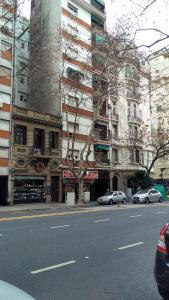 una calle de la ciudad con coches estacionados frente a los edificios en Apartamento Luz en Buenos Aires