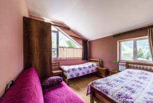 a bedroom with two beds and two windows at Guest House 15 in Kazbegi