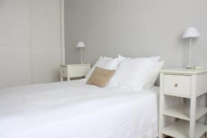 een witte slaapkamer met een wit bed en 2 nachtkastjes bij MADRID CENTER, WIFI (RETIRO IBIZA) in Madrid