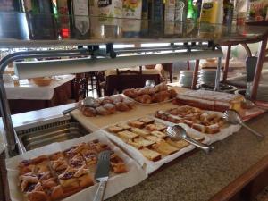 un montón de diferentes tipos de pasteles en un mostrador en Hotel Continental, en Lido di Jesolo