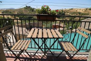 a table and two chairs on a balcony with a plant at La Locanda Di Cadì in Petralia Soprana