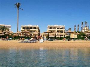 a beach with chairs and umbrellas on the beach at Apartment at Palm Beach Piazza in Hurghada
