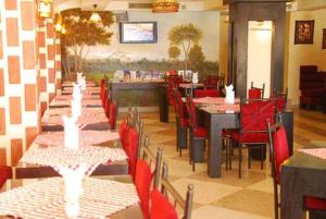 a restaurant with red chairs and tables and tablesktop at Apartment at Palm Beach Piazza in Hurghada