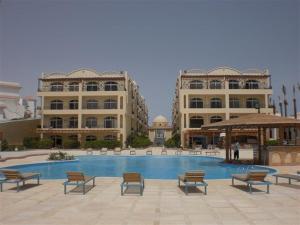a resort with a swimming pool and two large buildings at Apartment at Palm Beach Piazza in Hurghada