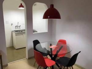 a dining room with a glass table and red chairs at Paulista Flat in São Paulo